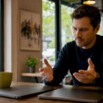 Hands comparing two laptops side-by-side