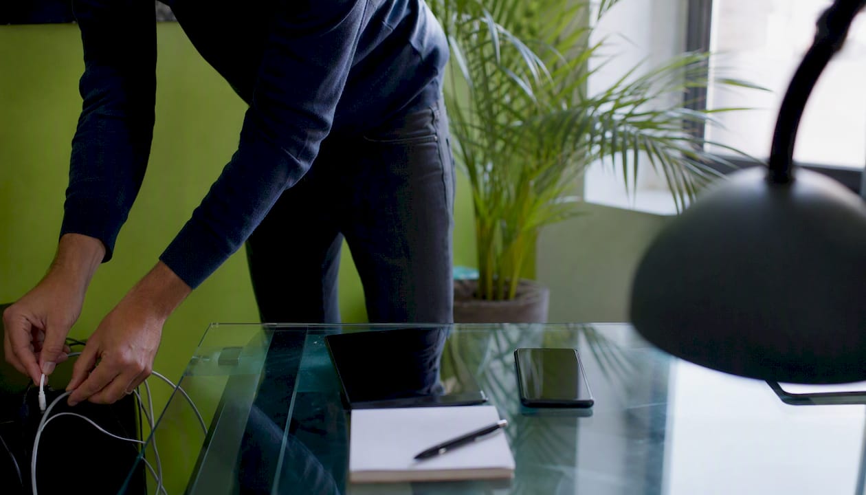 SME workspace with hands connecting a charger cable