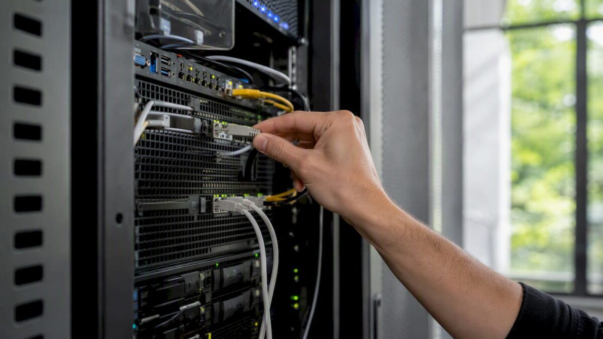 Hand unplugging network cable in data center