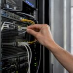 Hand unplugging network cable in data center