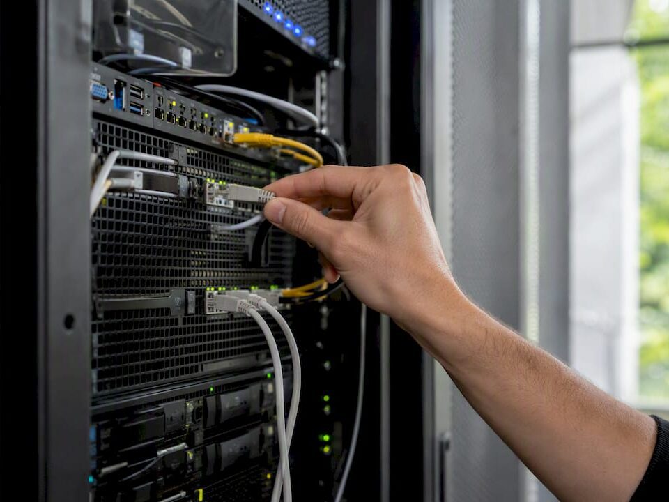 Hand unplugging network cable in data center
