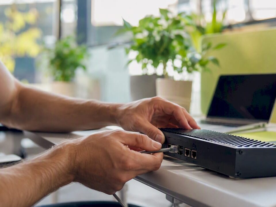 Hands connecting network cable to device