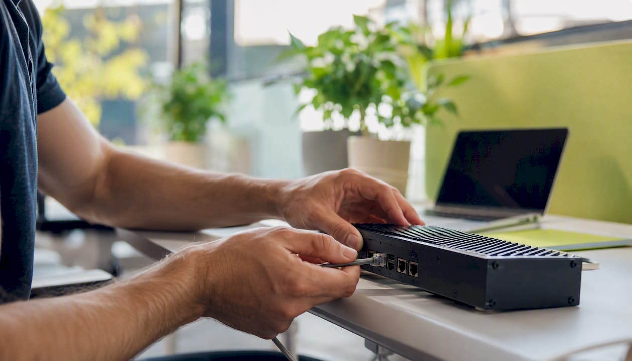 Hands connecting network cable to device