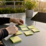 hands arranging sticky notes in SEO workspace