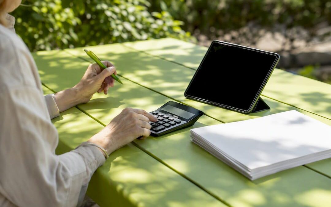 Hands calculating SEM budget at desk