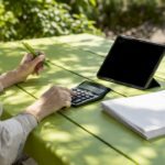 Hands calculating SEM budget at desk
