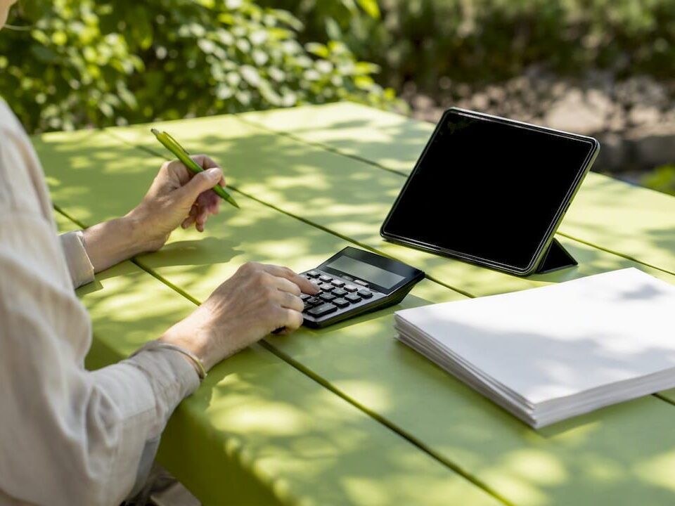 Hands calculating SEM budget at desk