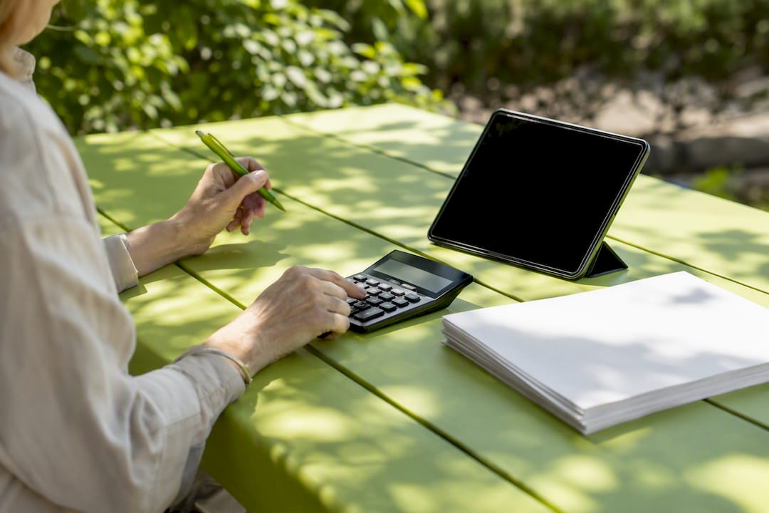 Hands calculating SEM budget at desk