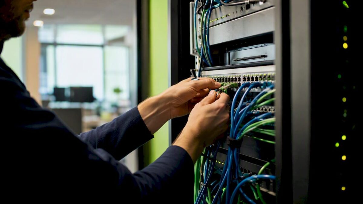 Hands connecting network cables in server room
