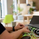 Hands connecting network cables in office