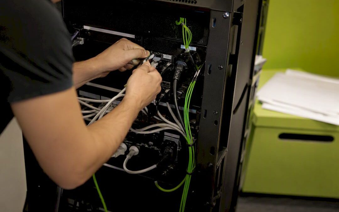 Hands connecting cables at a server