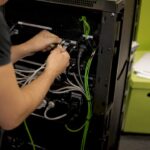 Hands connecting cables at a server