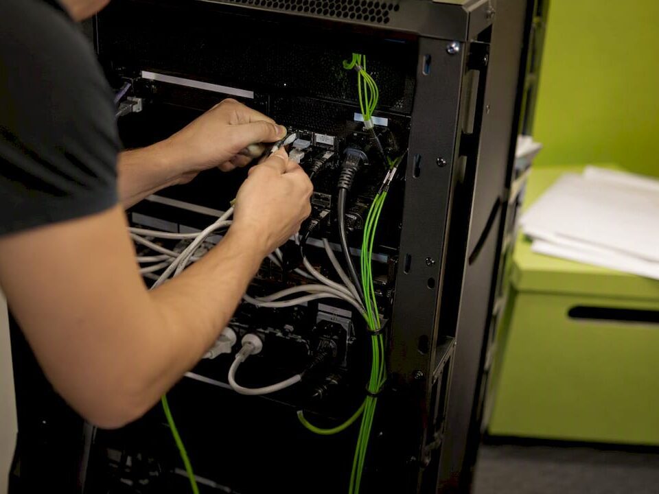Hands connecting cables at a server