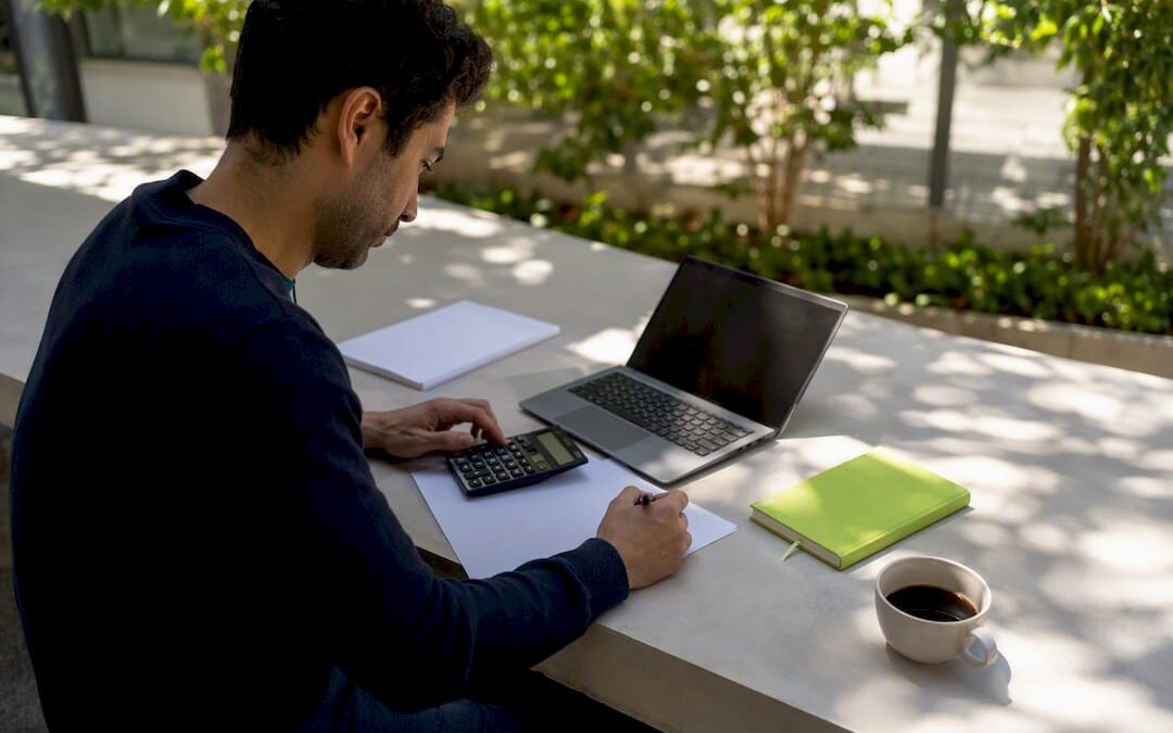 Hands calculating ROI on SME finance desk
