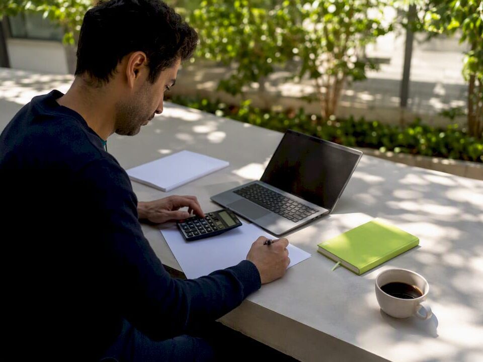 Hands calculating ROI on SME finance desk