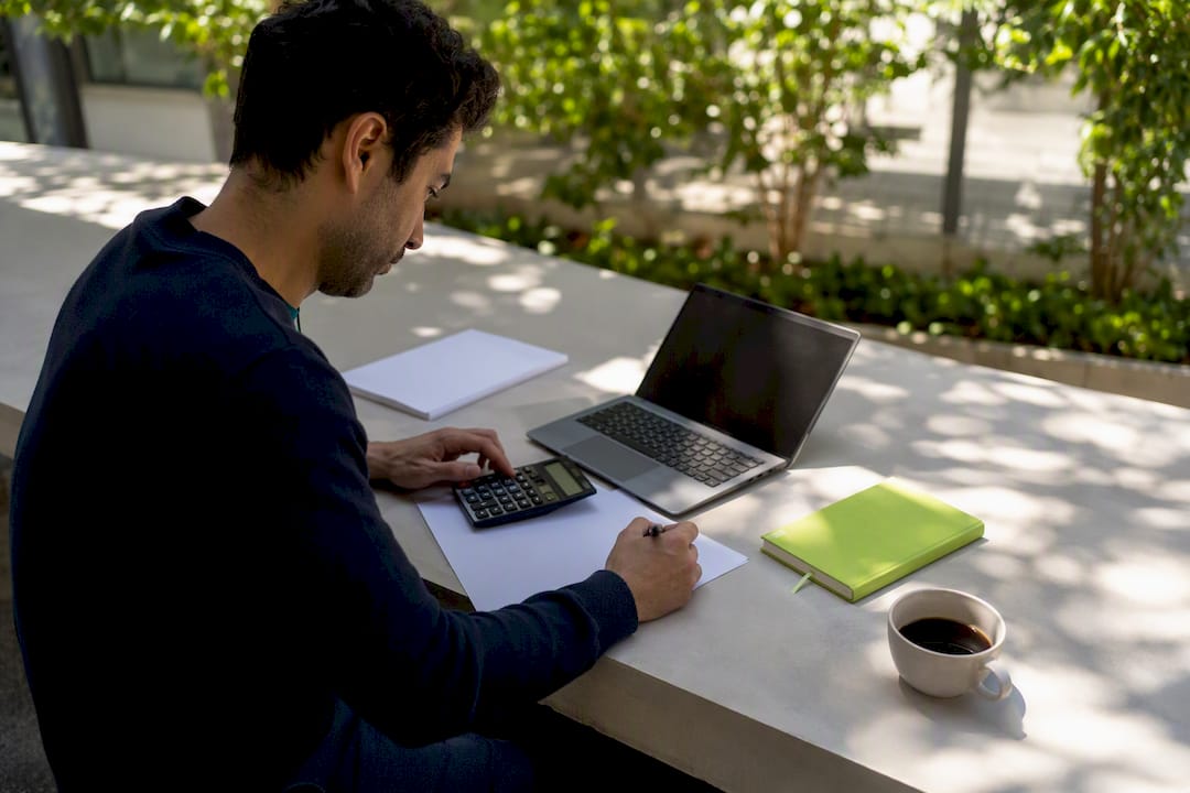1787884846552_Hands-calculating-ROI-on-SME-finance-desk Hands calculating ROI on SME finance desk